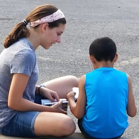 A teen volunteer ministering to a child